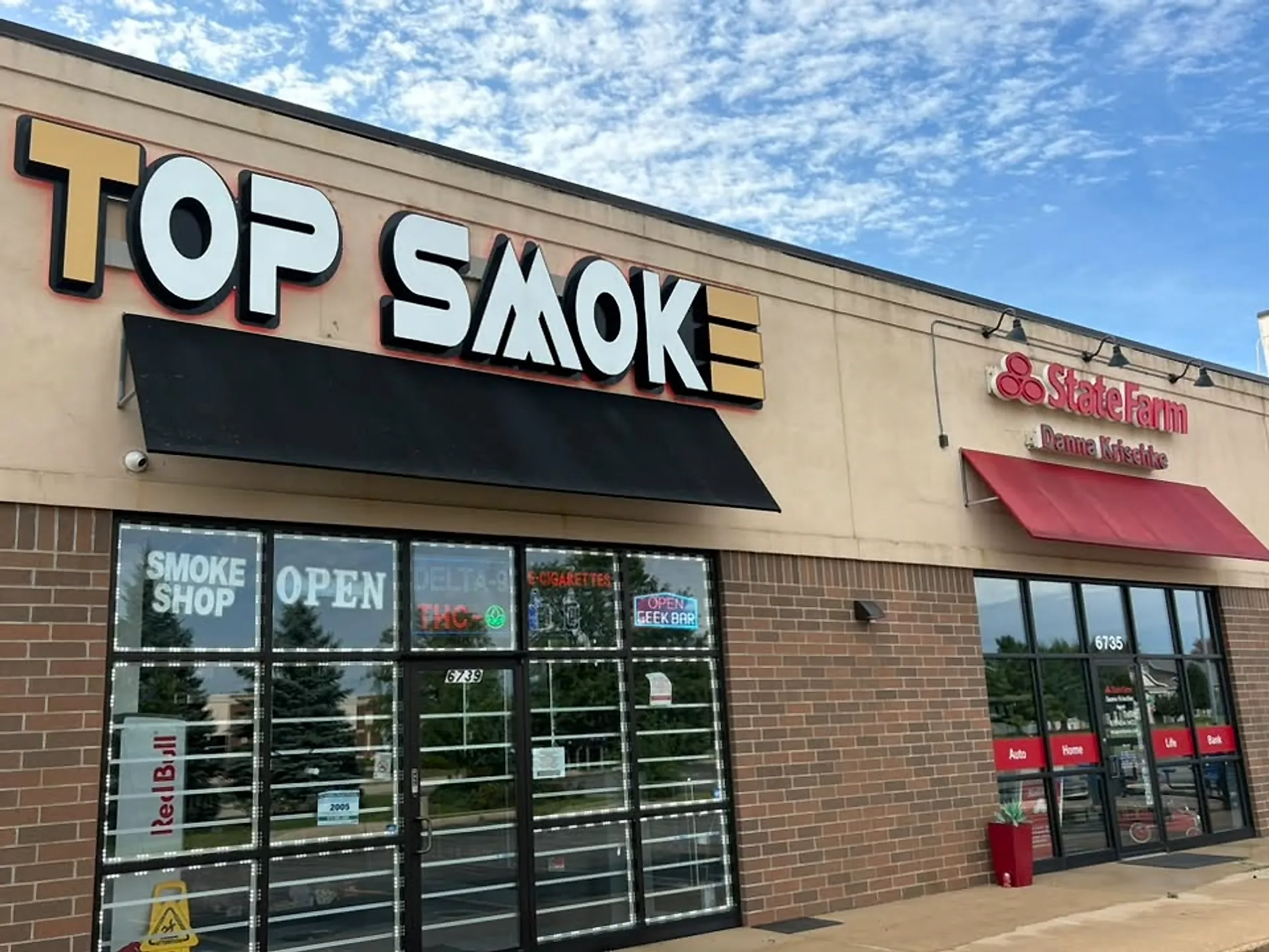 Smoke shop storefront and black awnings after a full frontage wash