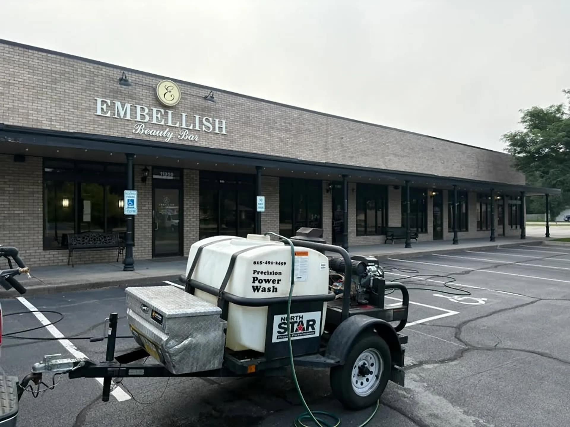 The Precision Power Wash trailer rig parked outside a storefront job